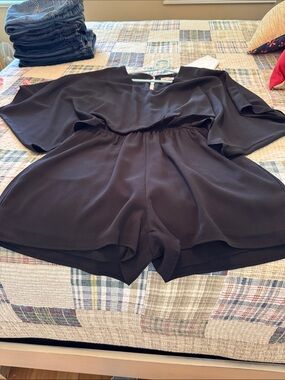 Main Strip Black Short Sleeve Romper in Solid Black. Medium